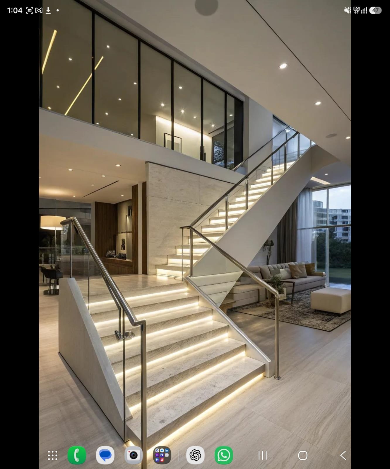 Frameless glass balustrade staircase beside a double-height glazed living room