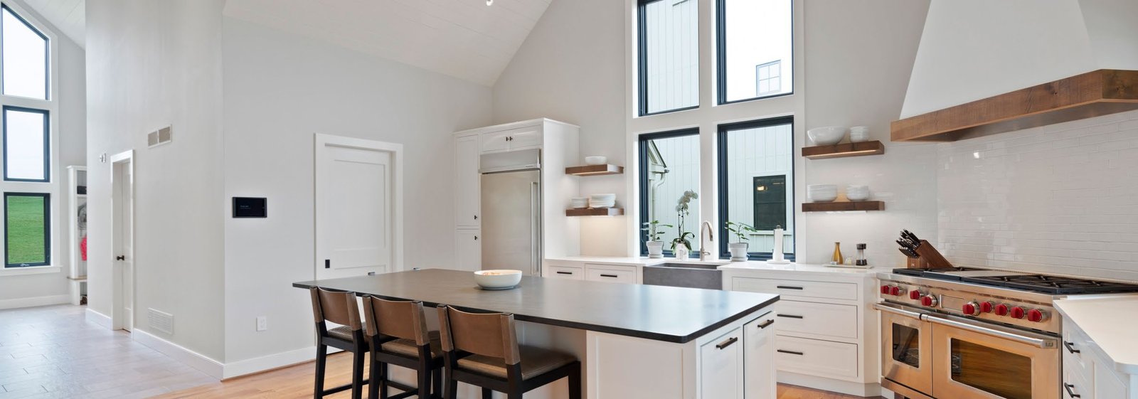 Loxone Starter plan — open-plan kitchen and living space with a Loxone Touch panel mounted on the wall