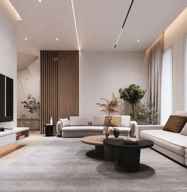Modern minimalist living room with backlit wood paneling and sculptural coffee tables